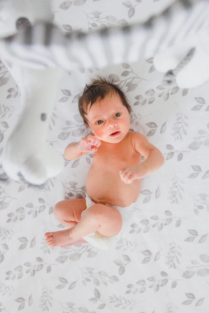 Ewing Newborn Session, Baby lays in crib looking in to the camera above her