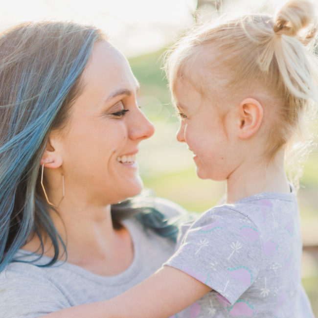 Spring Family Session, Mother is holding daughter. Mother and daughter are looking and smiling at each other. Wheaton Illinois, Northside Park