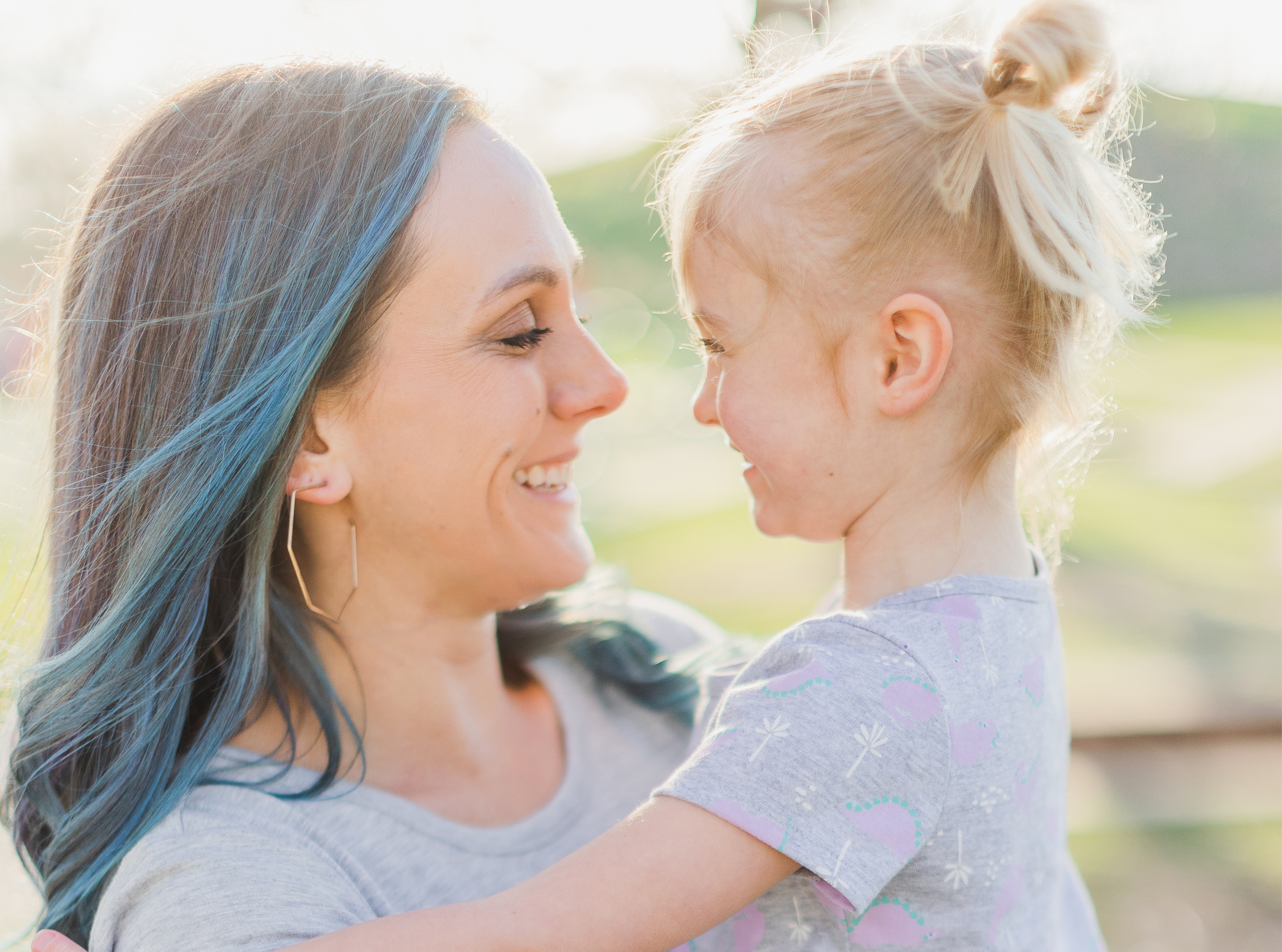 Spring Family Session, Mother is holding daughter. Mother and daughter are looking and smiling at each other. Wheaton Illinois, Northside Park