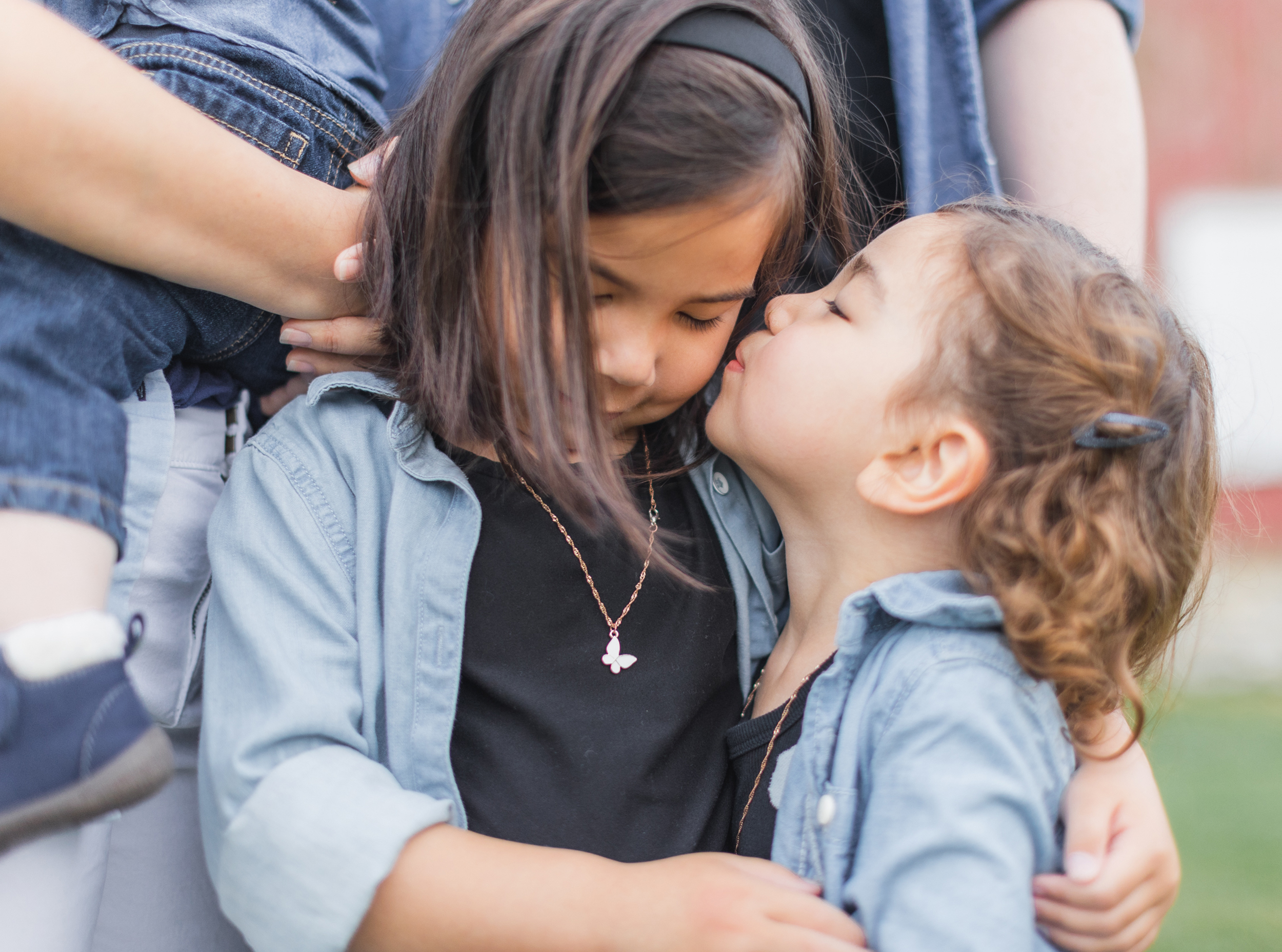 IL. LeRoy Oaks Forest Preserve. Youngest sister is giving oldest sister a kiss on the cheek