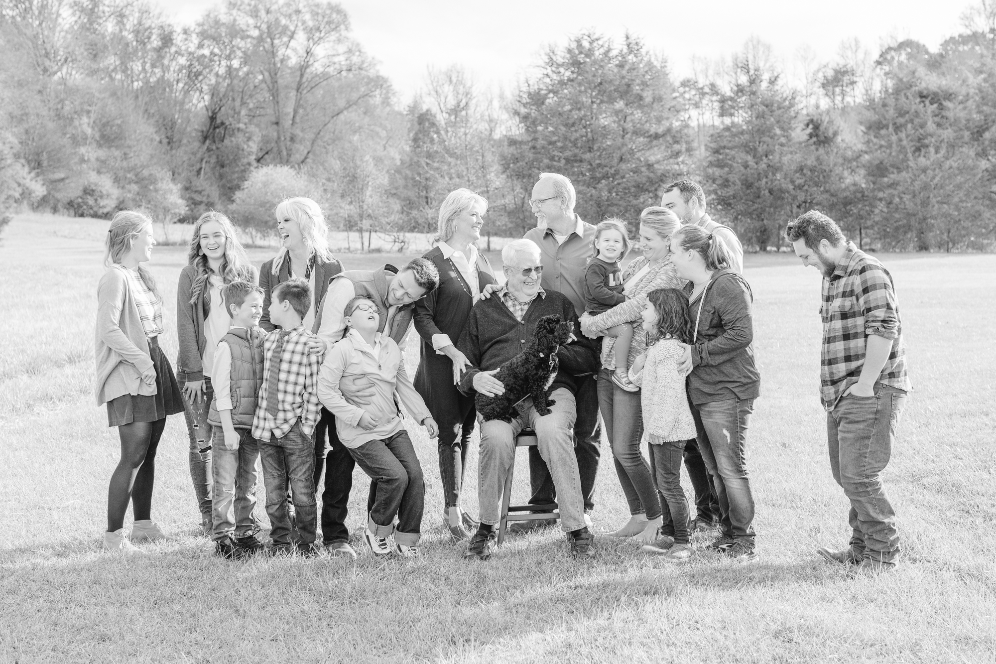 group family photo of all 4 generations during an extended family session. Everyone is looking at each other, laughing