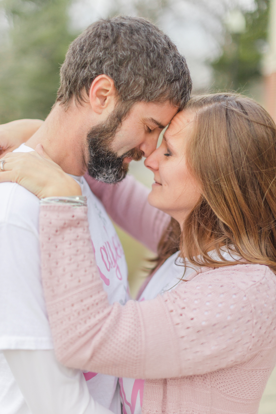 Parents are facing each other, noses touching. Both parents' eyes are closed while they are enjoying the moment