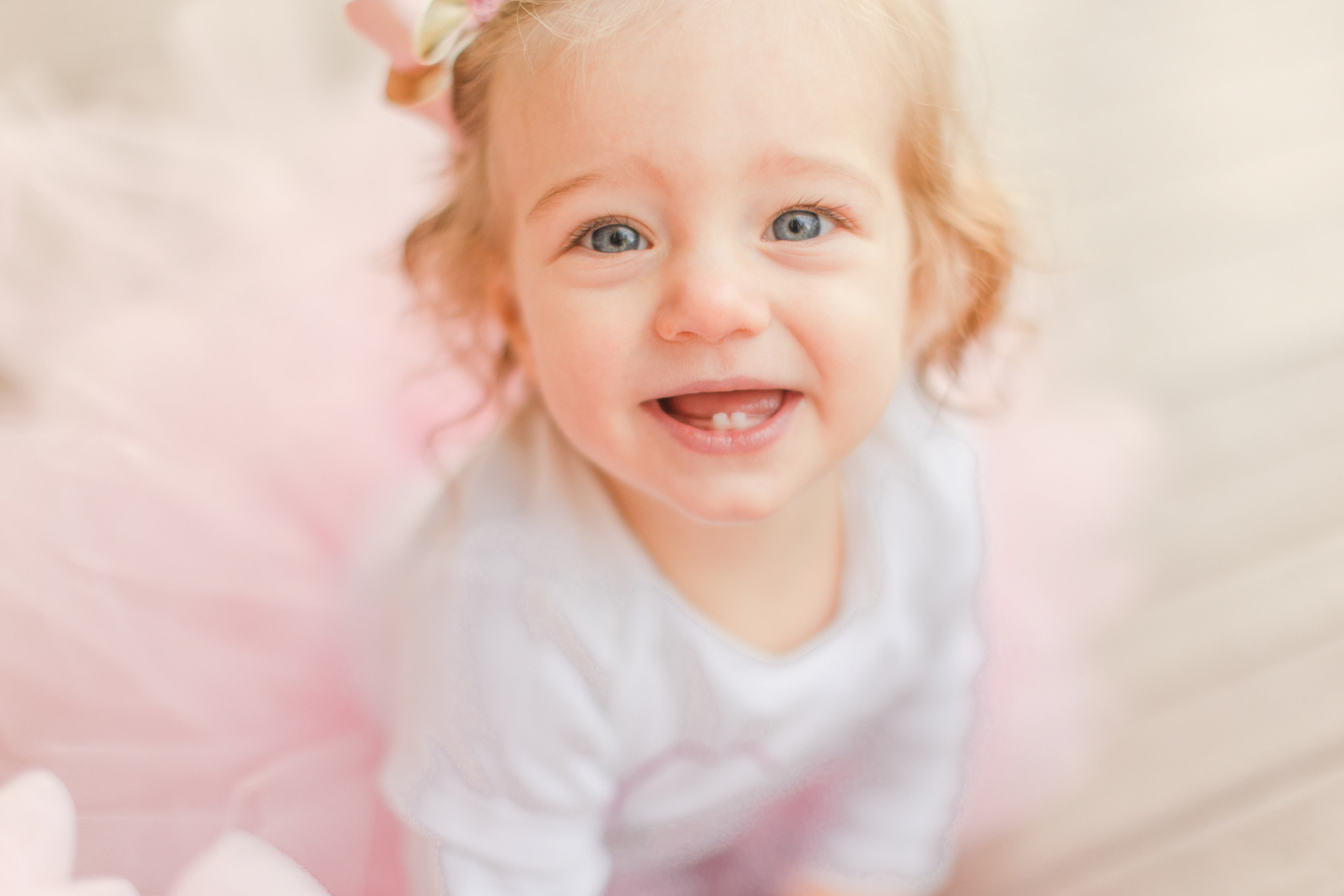 One year old sitting and laughing into the camera. Close up of her smile.