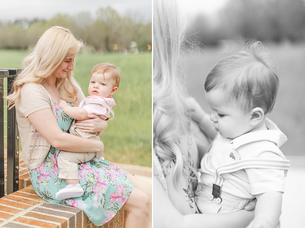 While Mom is sitting on a brick wall, she is holding her son, smiling at him. One year old is playing with moms hair during a mommy + me cake smash session