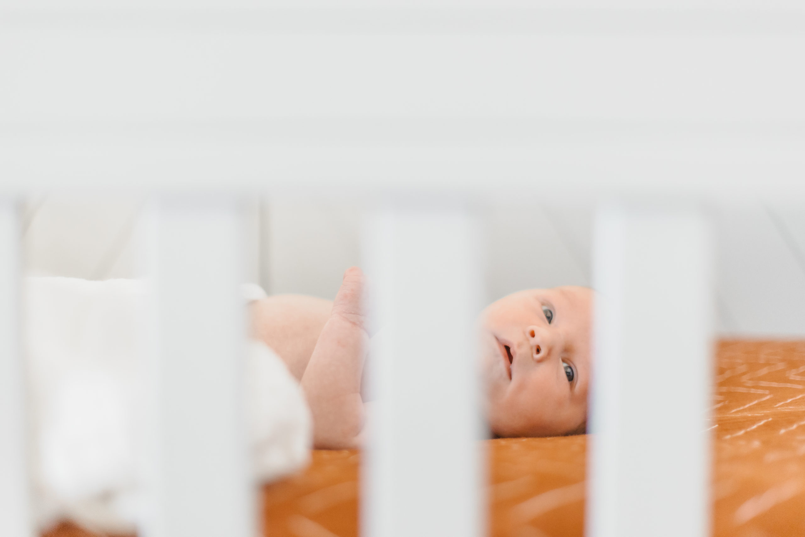 Detail shot of Newborns face laying in the crib during the lifestyle in home newborn session